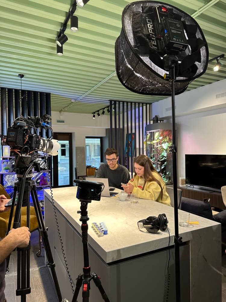 A film set: cameras, lights and a conversation at the table
