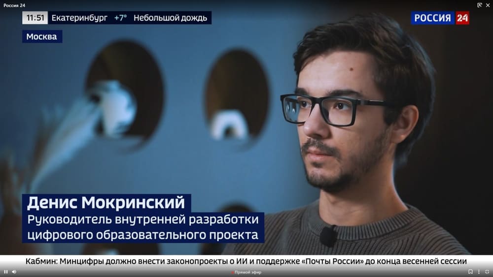A frame from the Rossiya 24 broadcast: a studio interview captioned “Denis Mokrinsky”